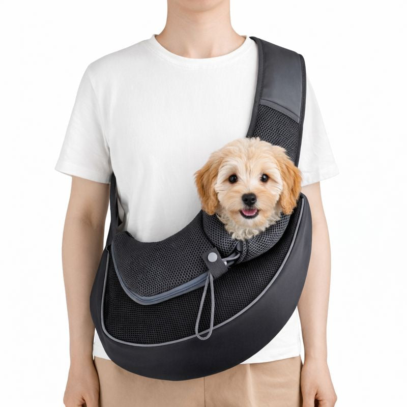 Person carrying a small dog in the black Ranger dog sling carrier