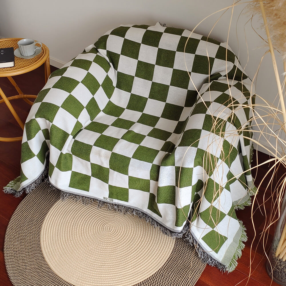 Sloane green checkerboard fringe throw draped over an armchair
