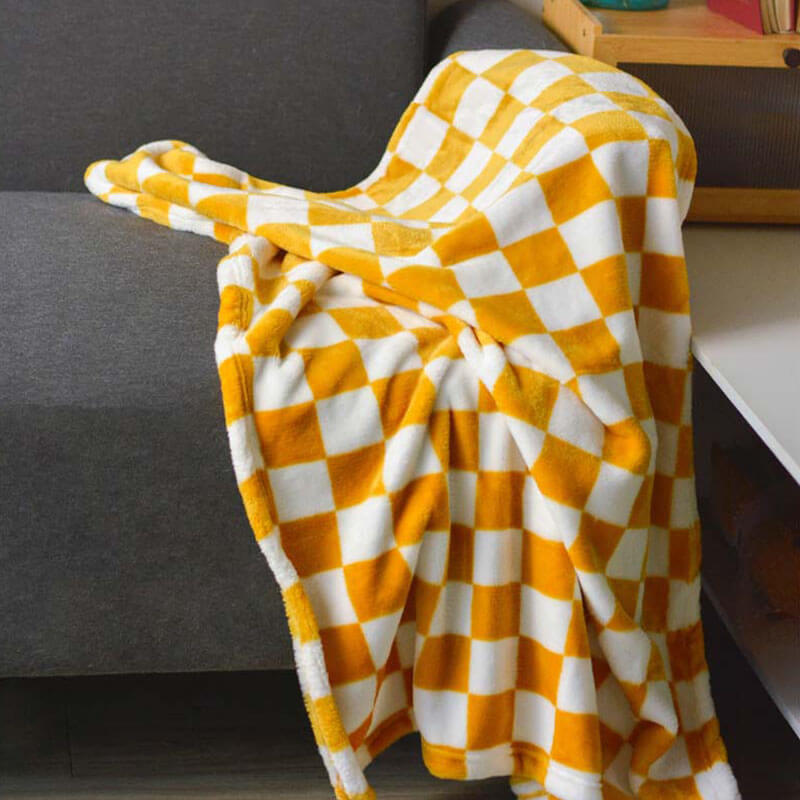 Meadow yellow chequered flannel dog blanket draped over a sofa