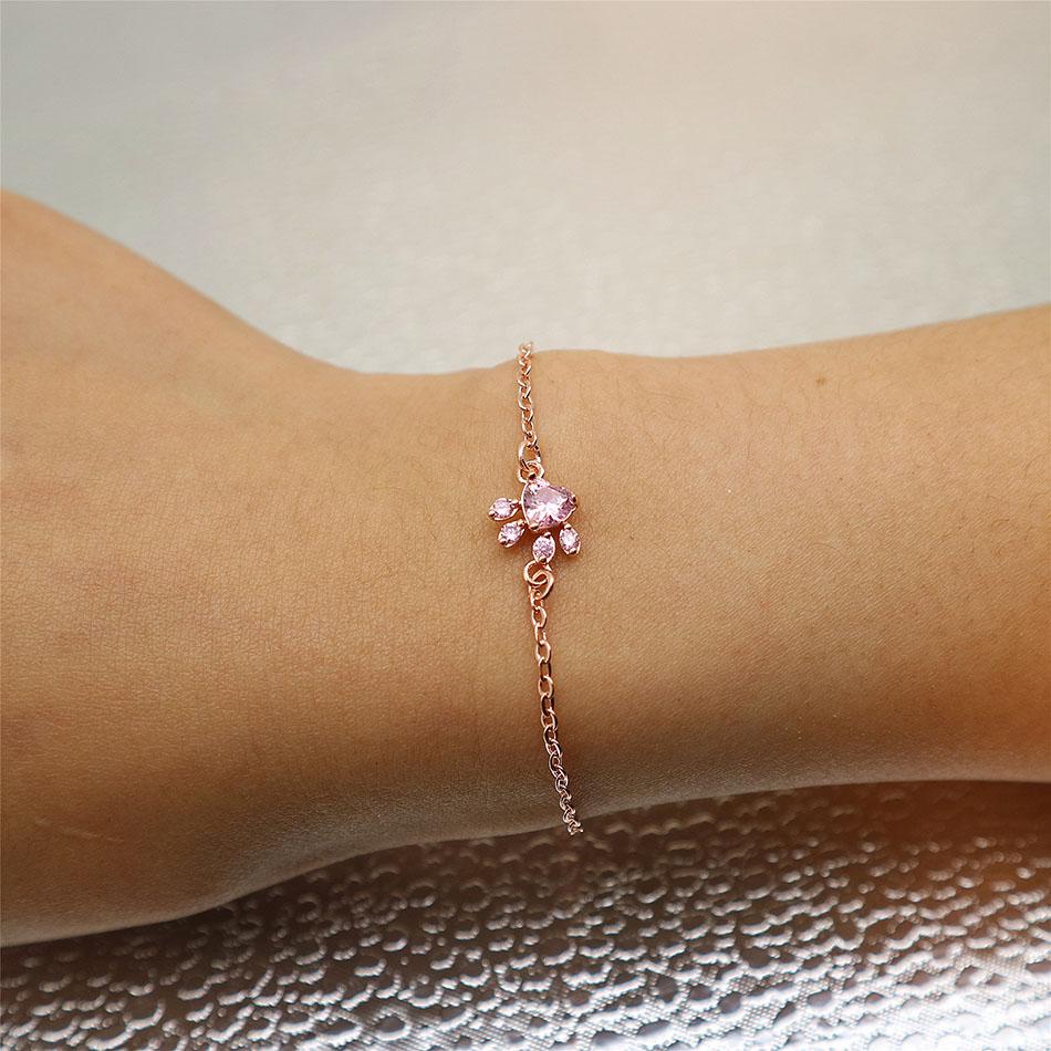 Rose quartz paw print bracelet on a woman's wrist