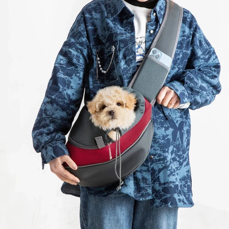 Man wearing the dark red Ranger dog sling carrier with his dog