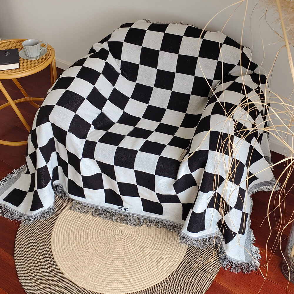 Sloane black checkerboard fringe throw draped over an armchair