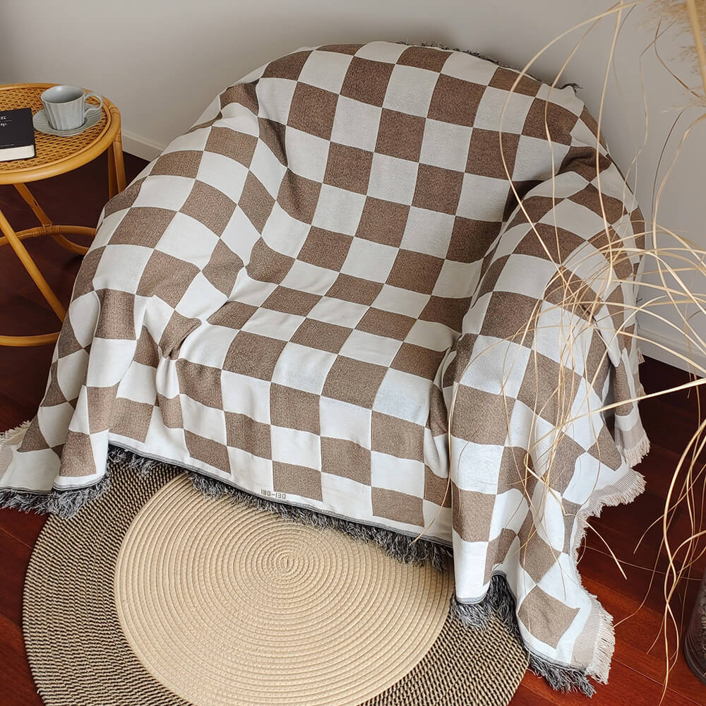 Sloane coffee checkerboard fringe throw draped over an armchair