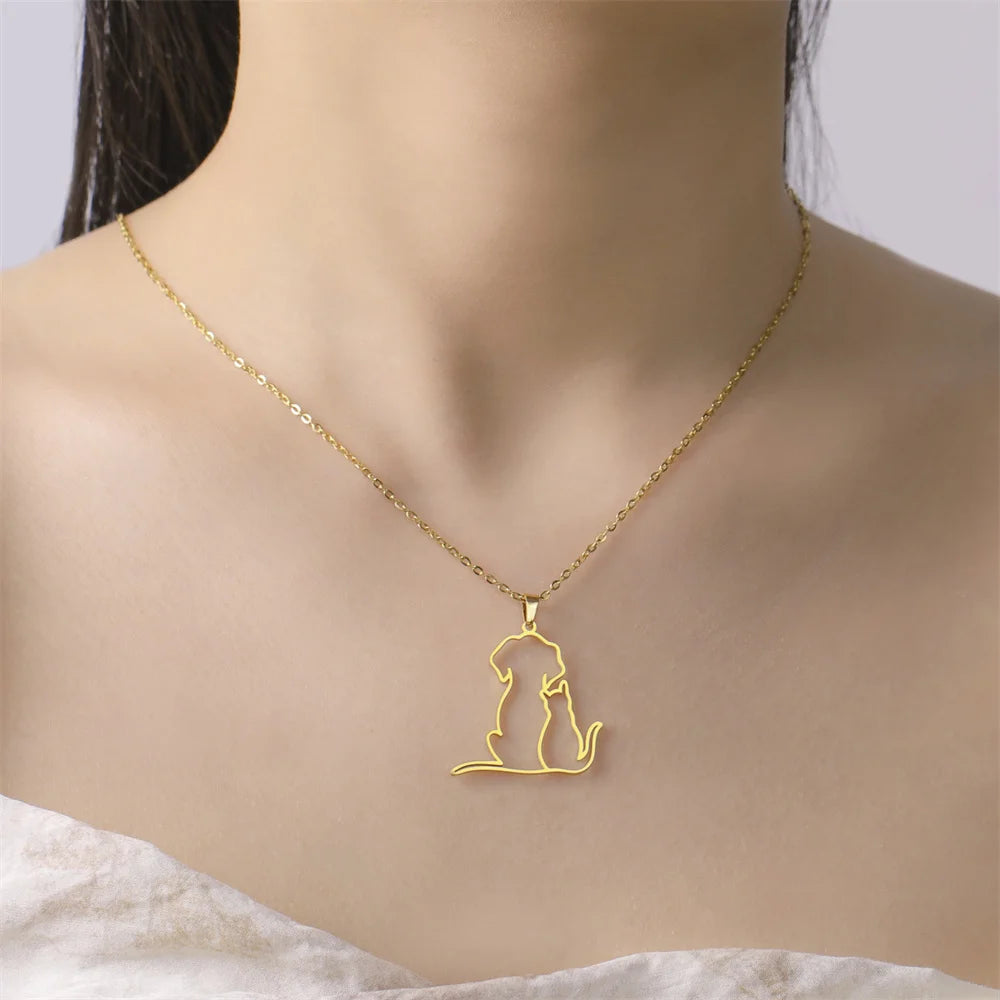 Woman wearing a gold dog and cat outline pendant necklace
