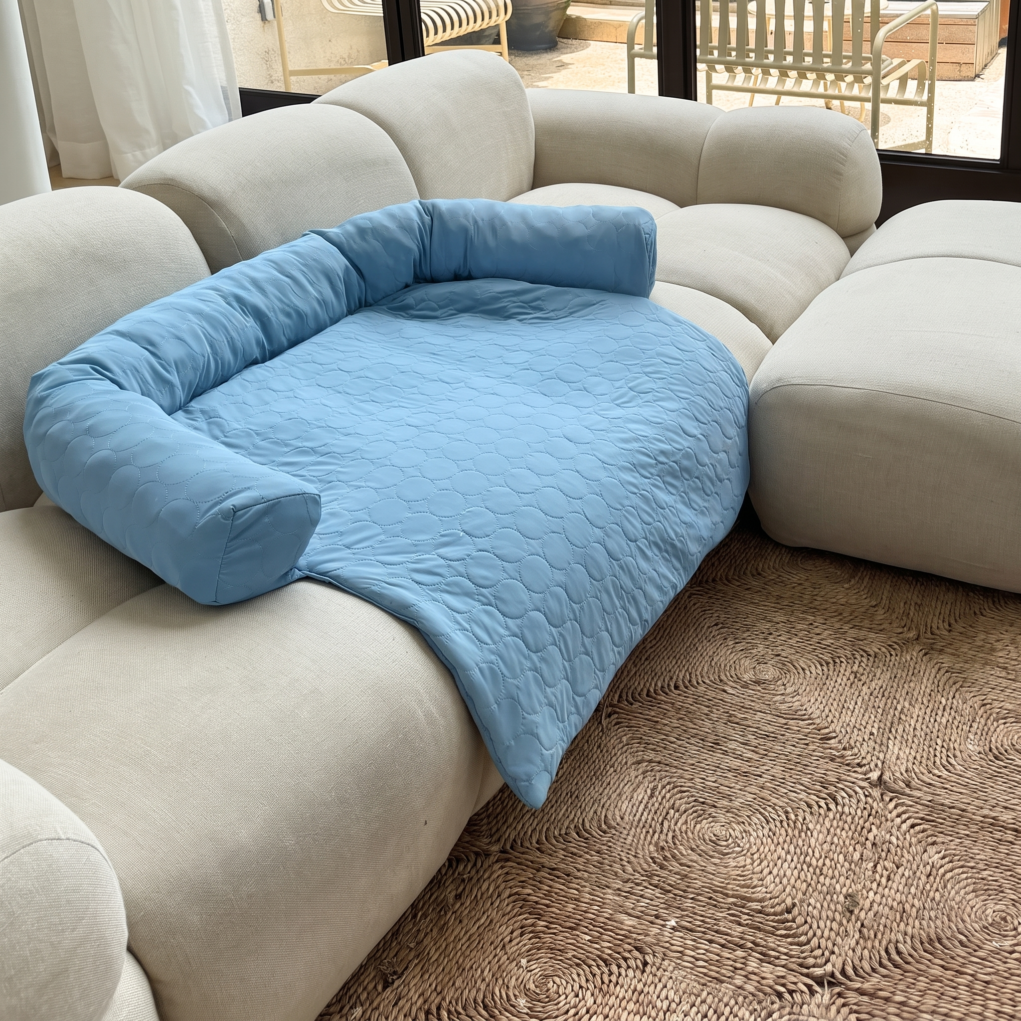 Light blue Nuzzinel Polar cooling sofa dog bed on a couch