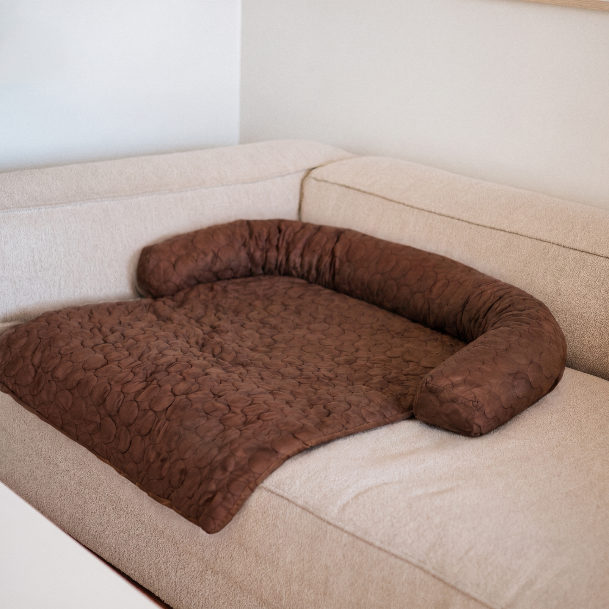 Coffee brown Nuzzinel Polar cooling sofa dog bed on a couch