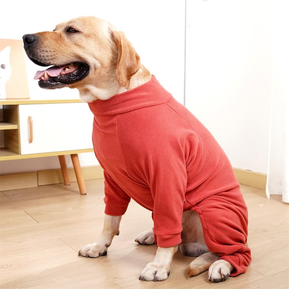 Dog sitting indoors in the red fleece dog pajamas