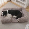 Border collie resting on the Nuzzinel Biscuit calming sofa dog bed