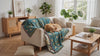 Wren Scandinavian Bird Throw – dog resting on the teal bird throw over a sofa