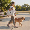 Woman walking her golden retriever while carrying the Fetch dog mom tote bag