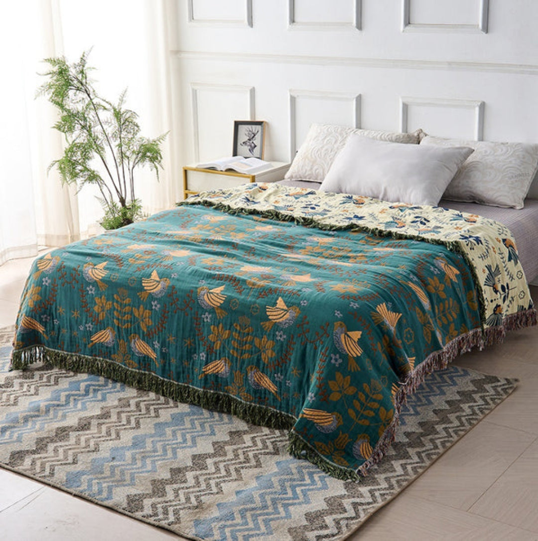 Wren Scandinavian Bird Throw – teal bird throw styled across a bed, top view